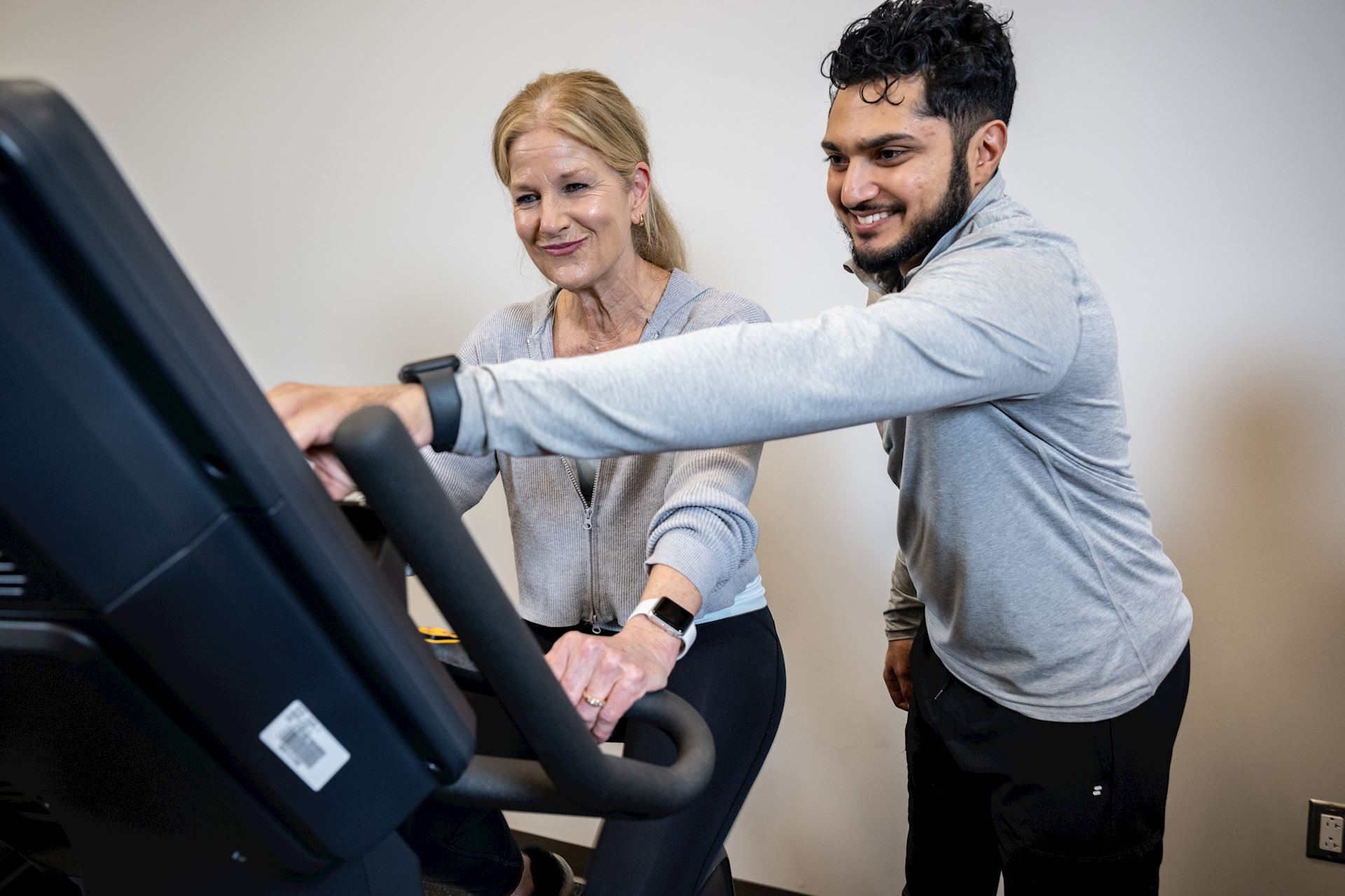 physical therapist assisting patient on stationary bike