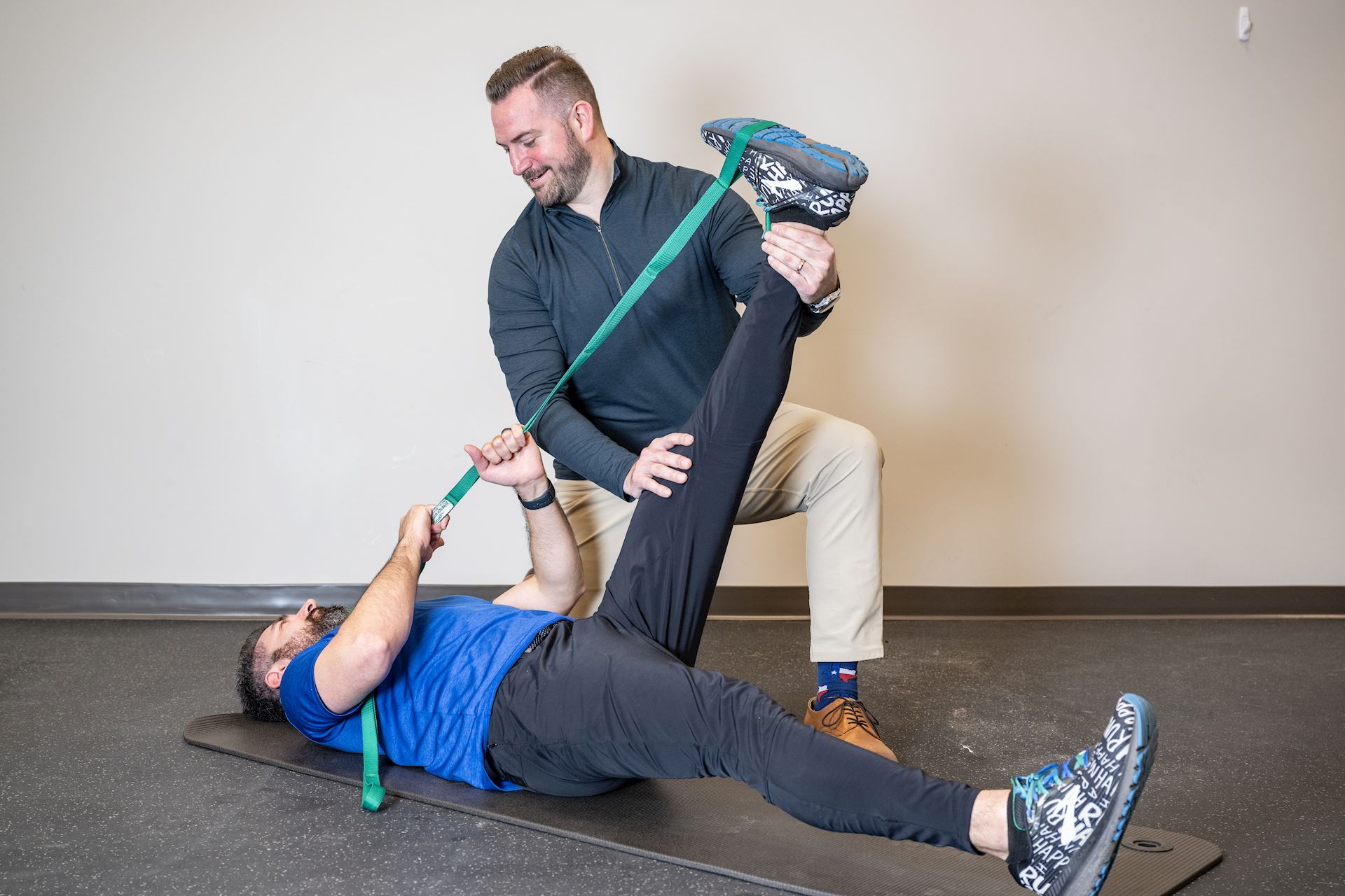 physical therapist assisting patient with leg stretching to enhance flexibility